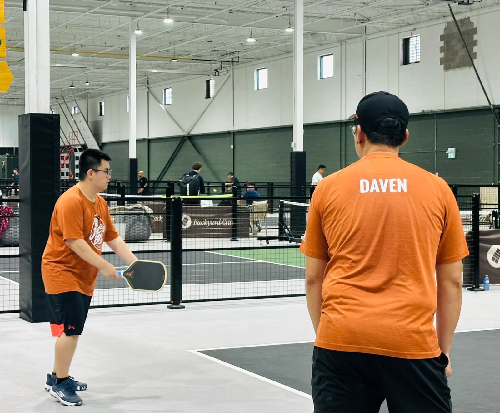 Daven, his name across the back of his shirt, watching Adrian get set to hit from the other side of the court